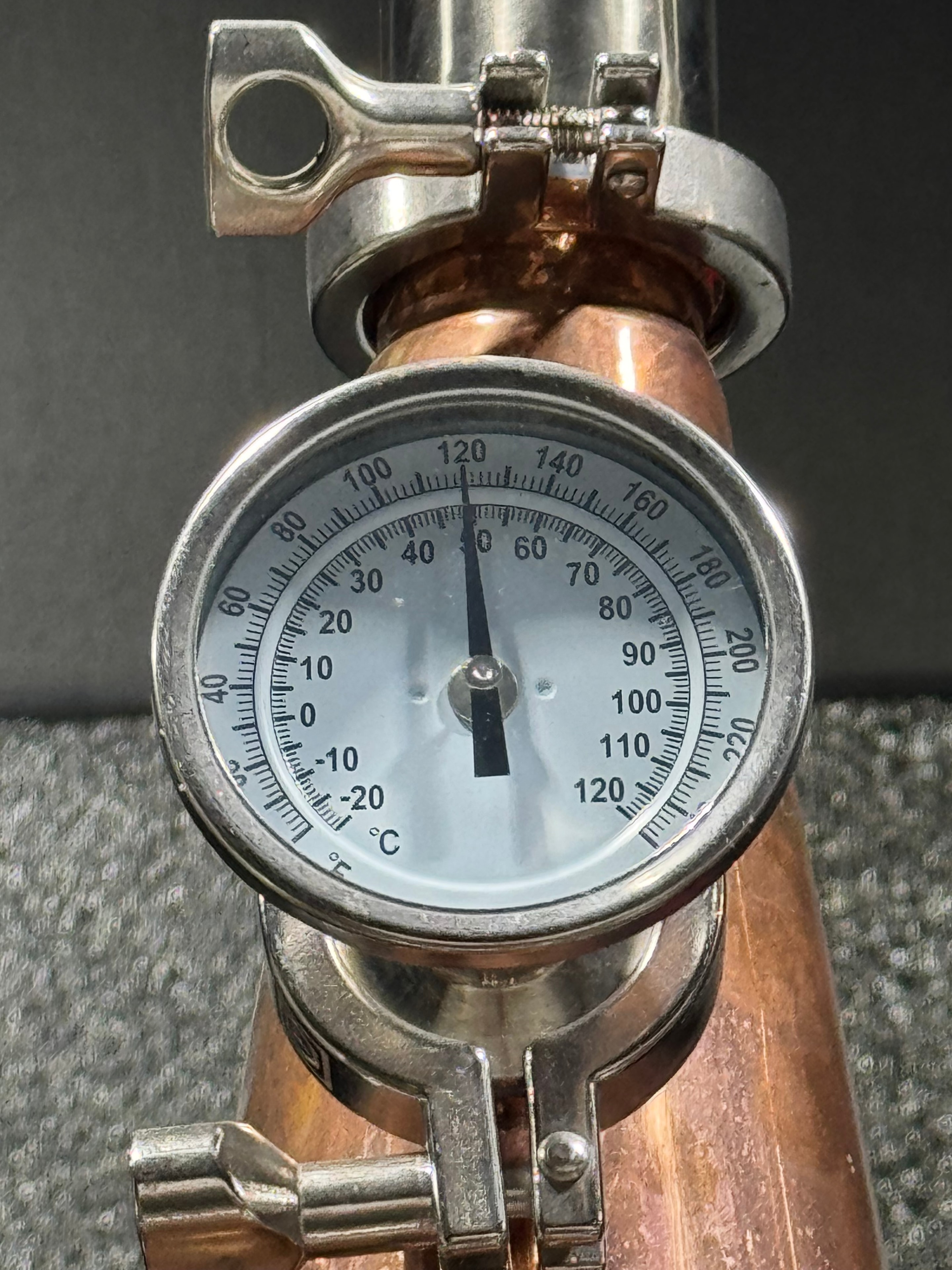 Temperature gauge on a copper still line during distillation